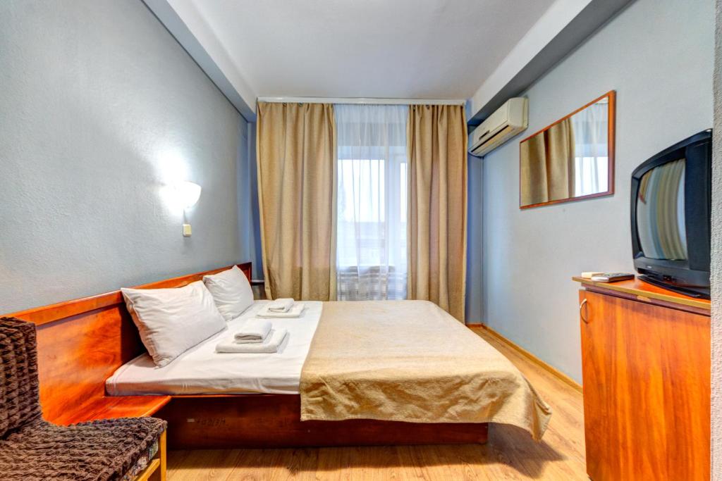 a hotel room with a bed and a tv at Holosiyvsky Hotel in Kyiv
