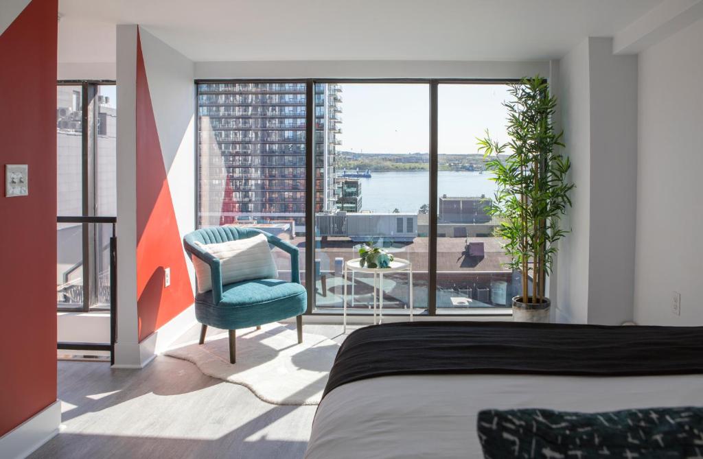 Schlafzimmer mit einem Bett und Blick auf das Wasser in der Unterkunft Cameo Hotel and Suites in Halifax