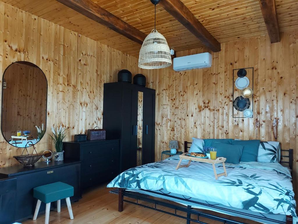 ein Schlafzimmer mit einem Bett und einer Holzwand in der Unterkunft Drvena kuca za odmor Cvetkovic brdo 