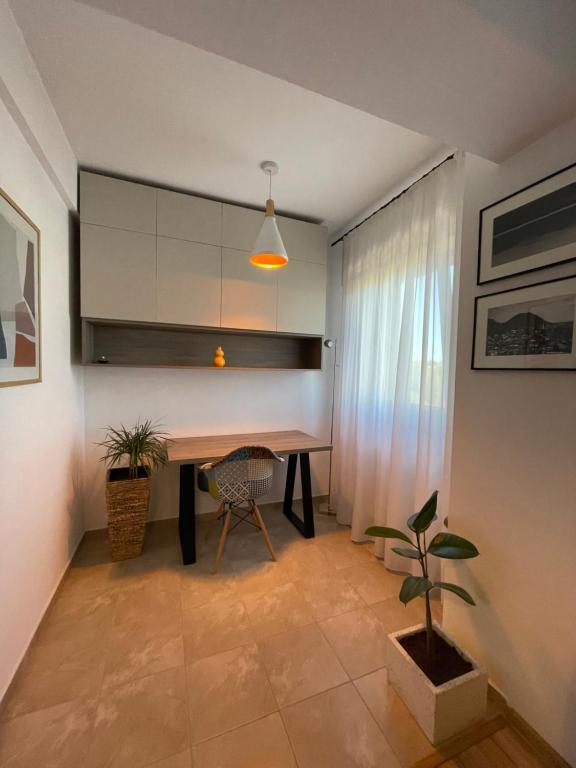 a dining room with a table and a potted plant at Cozy Apartment - near Airport and Palas Mall in Iaşi