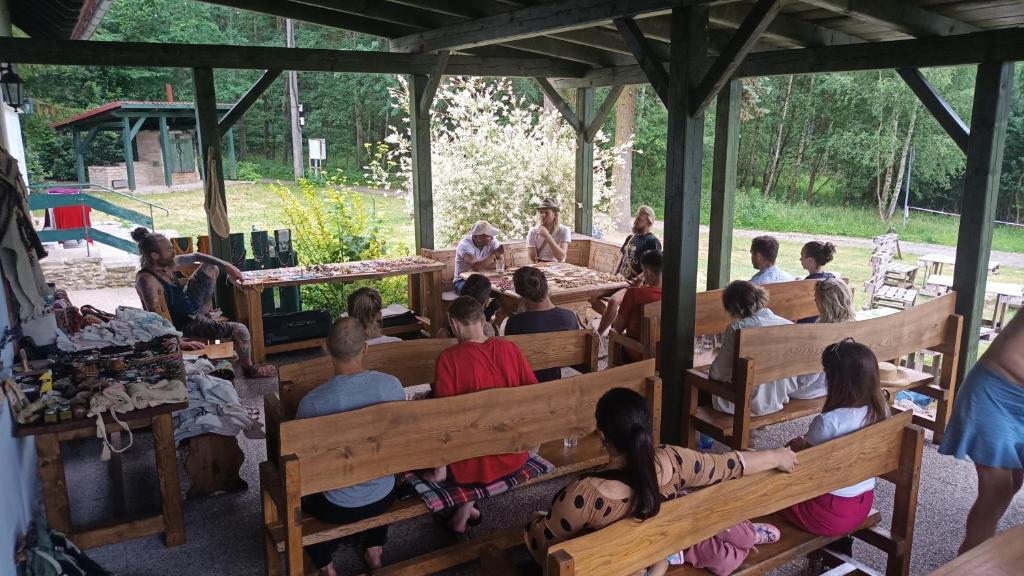 a group of people sitting on benches in a pavilion at Penzion Kairos in Klokočí