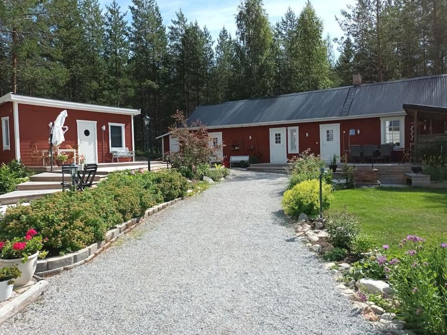 a barn with a driveway leading to a building at Torpet - Bed and Breakfast med charm in Norrfjärden