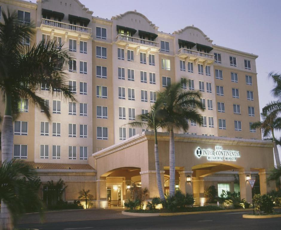 duży budynek z palmami przed nim w obiekcie Real Intercontinental Metrocentro Managua, an IHG Hotel w mieście Managua