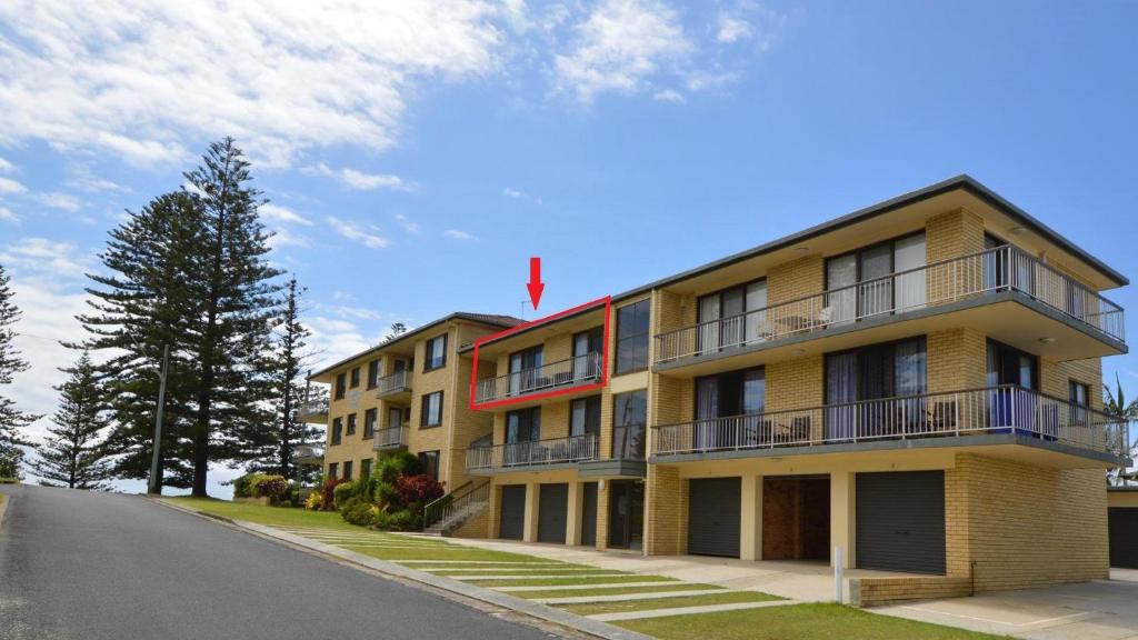 a yellow apartment building with a blue sky at Flinders Lodge unit 9 in Yamba