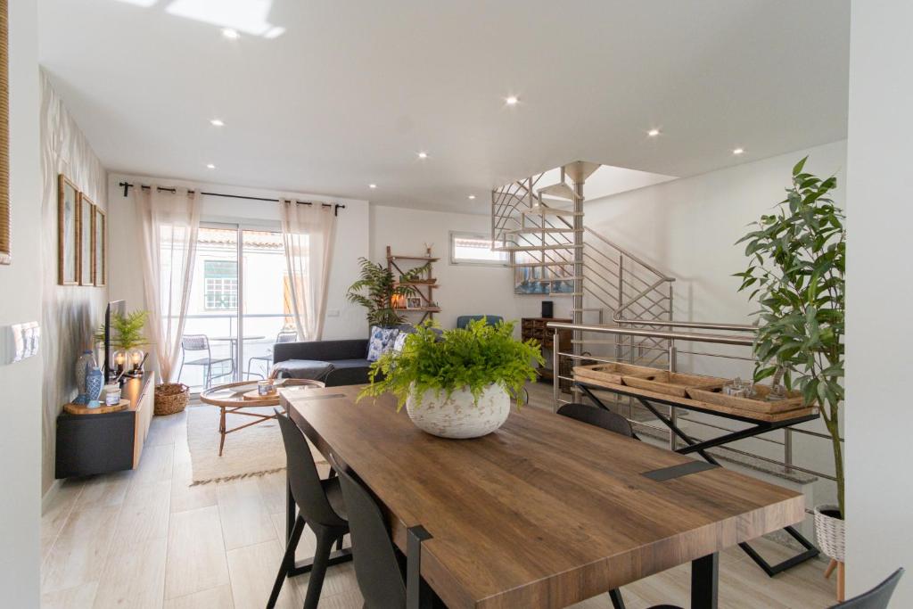 Una sala de estar con una mesa y sillas de madera. en Feel Nazaré - Batalha 124, en Nazaré
