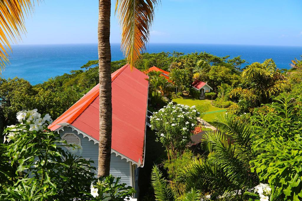 een huis met een rood dak en een palmboom bij Mount Edgecombe Boutique Hotel in Maran