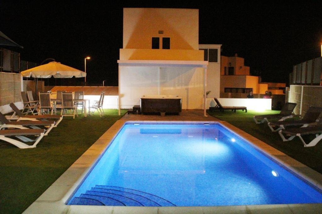 una piscina frente a una casa por la noche en Villa Cristallo en Costa Adeje, en Playa de las Américas