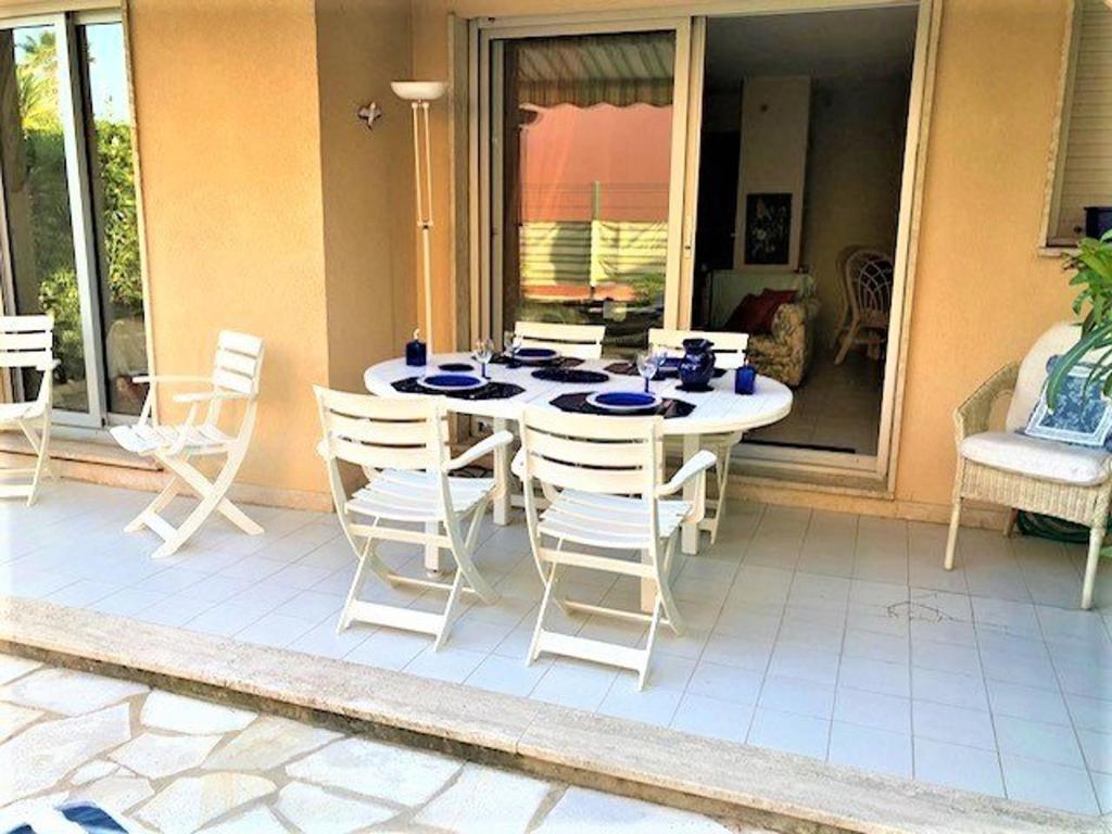 une table blanche et des chaises sur une terrasse dans l'établissement Appartement 3 pièces avec terrasse proche plage à Cavalaire-sur-Mer - FR-1-226B-66, à Cavalaire-sur-Mer