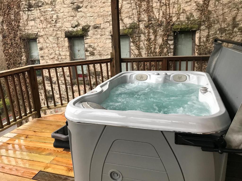 einen Whirlpool auf einer Terrasse mit einem Balkon in der Unterkunft Private Luxury Suite with Hot Tub Downtown Eureka Springs in Eureka Springs