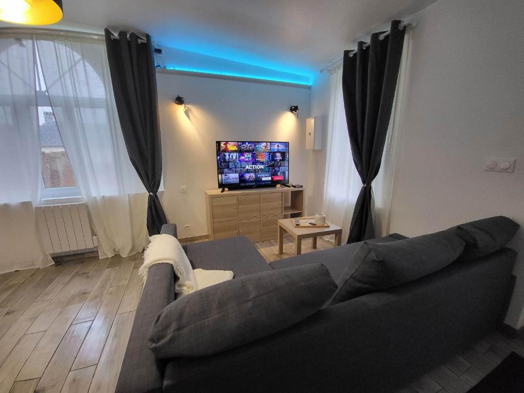 Gite des Rêves : غرفة معيشة مع أريكة وتلفزيون بشاشة مسطحة