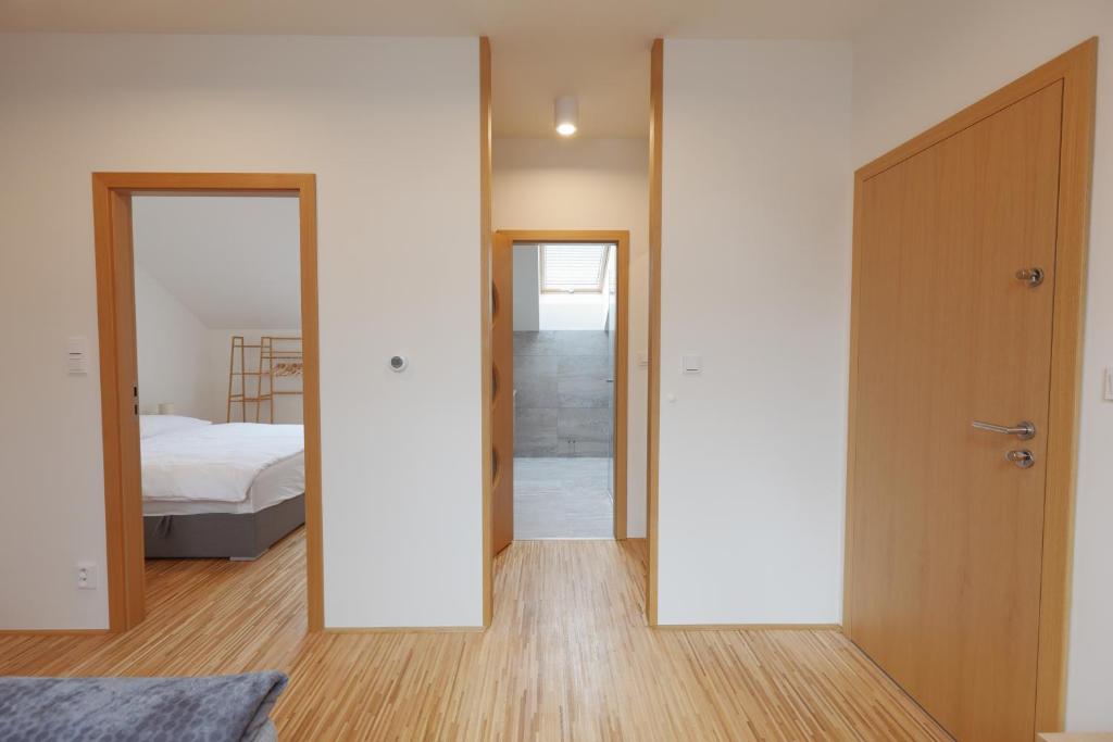 - une chambre avec un lit et une porte avec un miroir dans l'établissement Apartmány U Květné zahrady, à Kroměříž