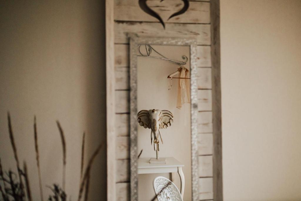 a reclaimed mirror with a bird on it in a living room at Drwalski Zakątek in Zatory