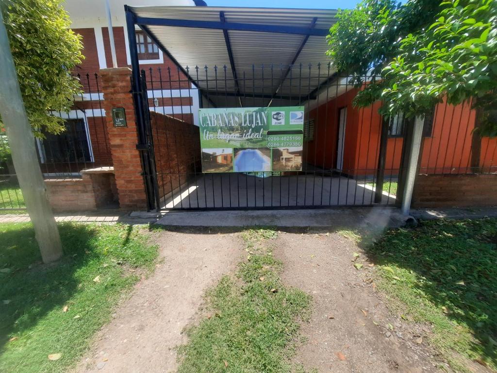 una puerta con un cartel delante de un edificio en Cabañas Lujan en El Volcán