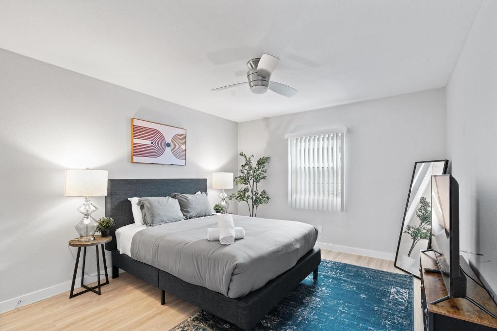 ein weißes Schlafzimmer mit einem Bett und einem Deckenventilator in der Unterkunft Evonify Stays - Highland - Stylish Furnished Apartments in Austin