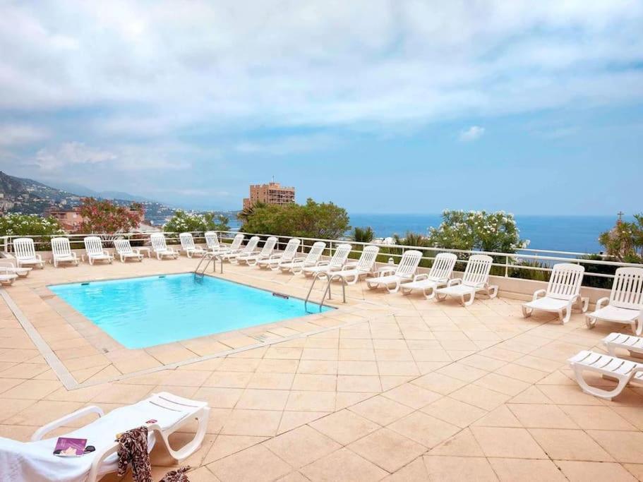 - un ensemble de chaises et une piscine sur une terrasse dans l'établissement Monaco Beausoleil "La maison de Marie", à Beausoleil
