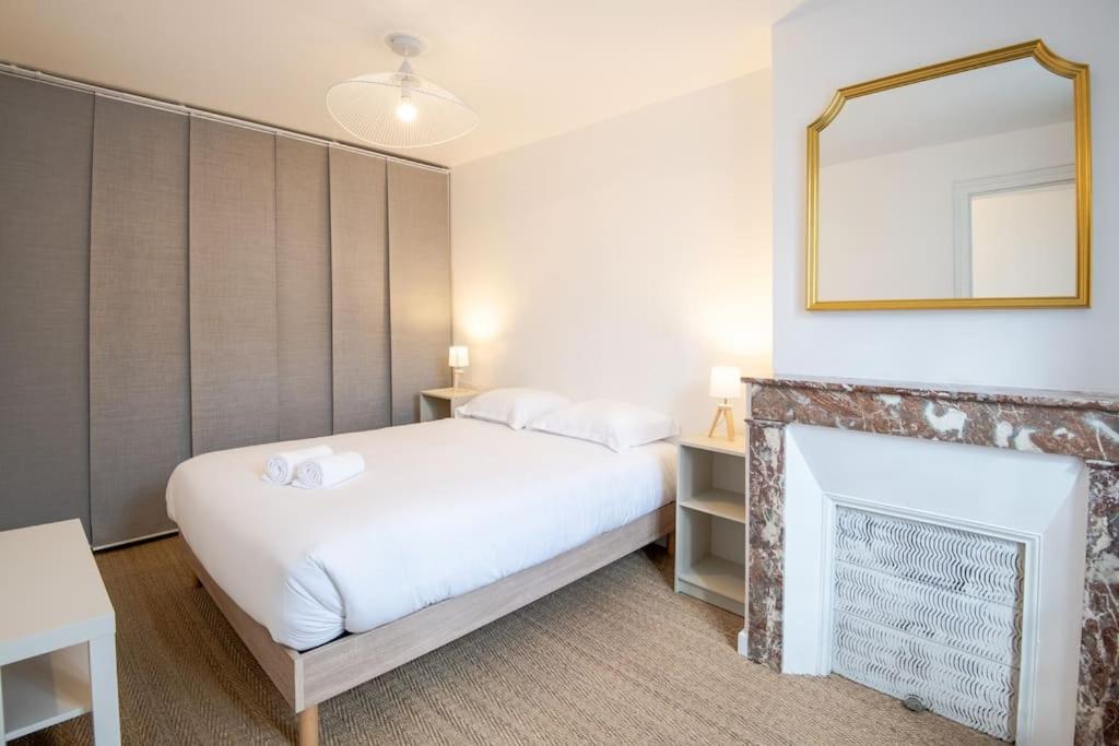 una camera con letto bianco e camino di Petit T2 Centre-Ville a Tours