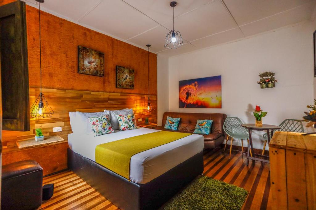 um quarto com uma cama, um sofá e uma mesa em The Garden Lleras 10 em Medellín