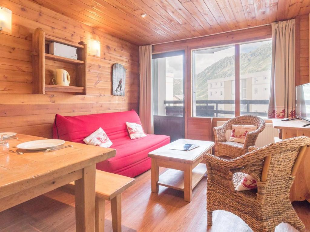 a living room with a red couch and a table at Appartement Montgenèvre, 2 pièces, 6 personnes - FR-1-330D-68 in Montgenèvre