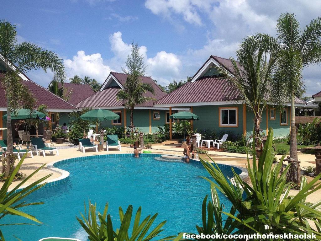 a swimming pool in front of a house at Coconut Homes Khao Lak in Khao Lak