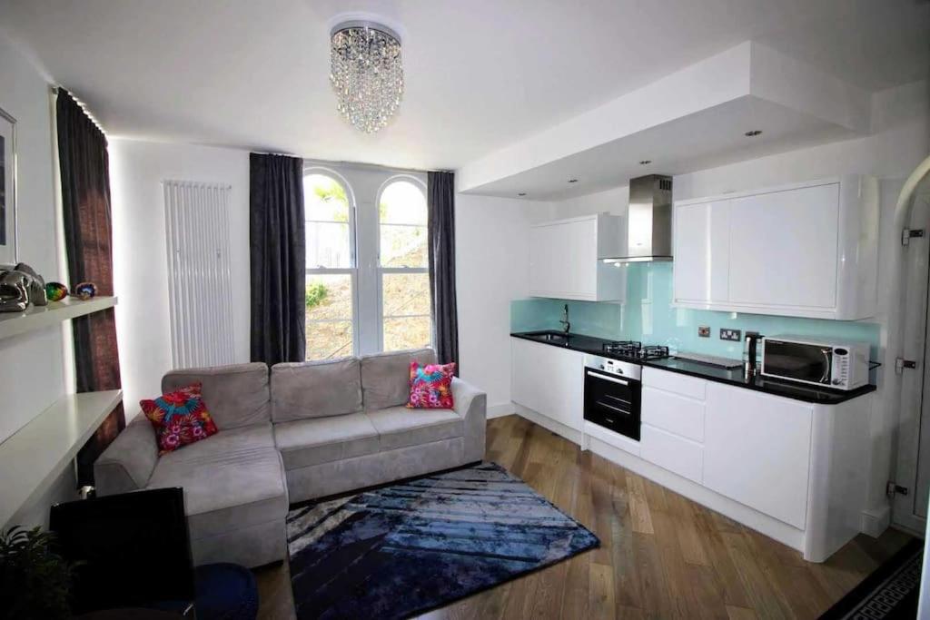 a living room with a couch and a kitchen at Boutique Apartment Brixham in Brixham
