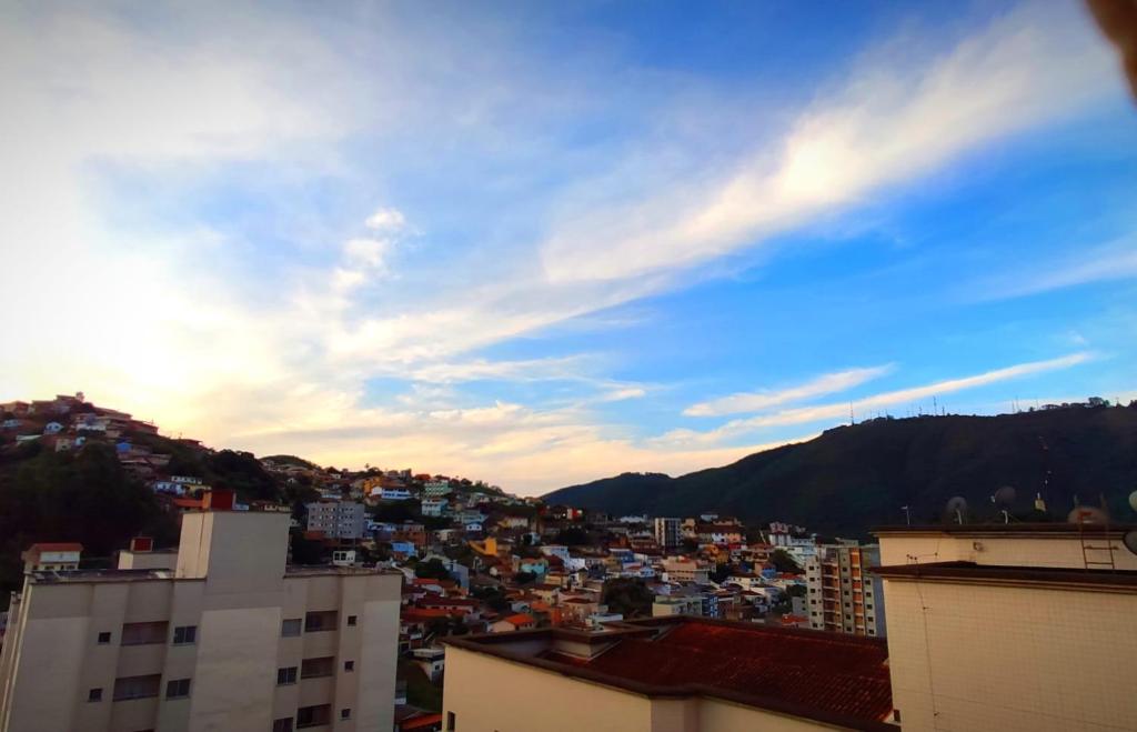 Blick auf eine Stadt mit Gebäuden und den Himmel in der Unterkunft Aconchego Poços de Caldas in Poços de Caldas