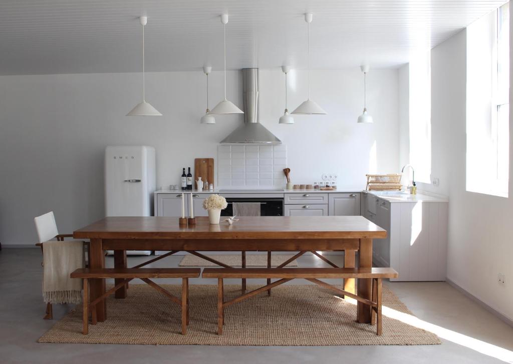 a kitchen with a wooden table and a wooden bench at A Padaria Farmhouse in Cinfães