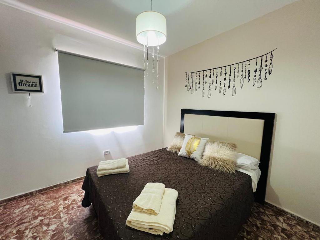 1 dormitorio con 1 cama con toallas en San Luis Apartment en San Luis