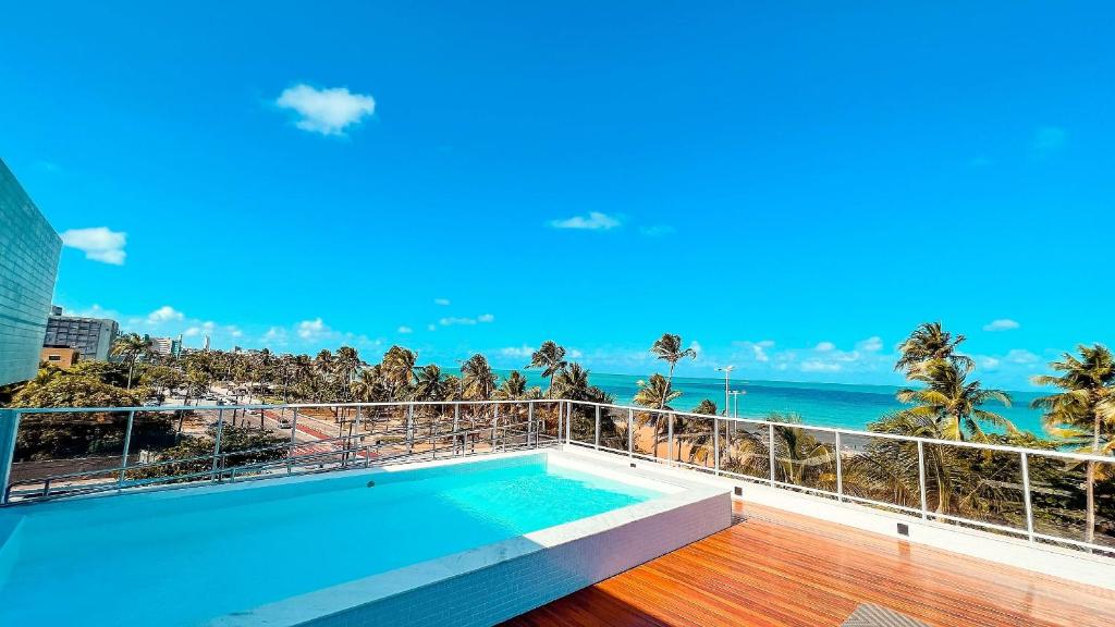 a swimming pool on a balcony with a view of the ocean at Puerto Ventura Cabo Branco Beira-mar Genius Flats in João Pessoa