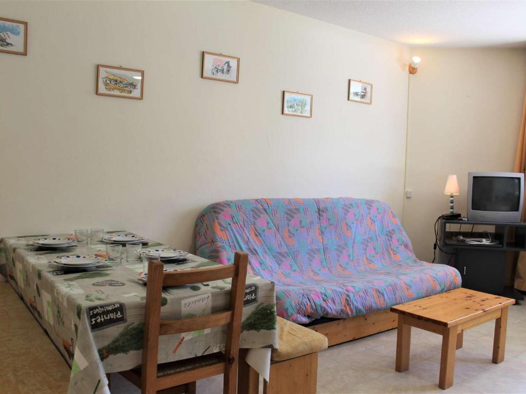 sala de estar con mesa y sofá en Appartement Vars, 1 pièce, 6 personnes - FR-1-330B-106, en Vars