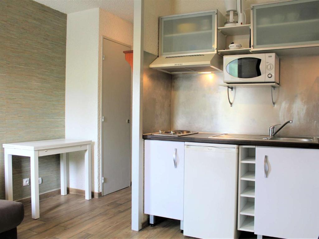 a kitchen with white cabinets and a microwave at Appartement Vars, 1 pièce, 2 personnes - FR-1-330B-119 in Vars