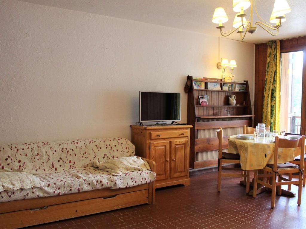 ein Wohnzimmer mit einem Sofa und einem Tisch mit einem TV in der Unterkunft Appartement Vars, 1 pièce, 4 personnes - FR-1-330B-124 in Vars