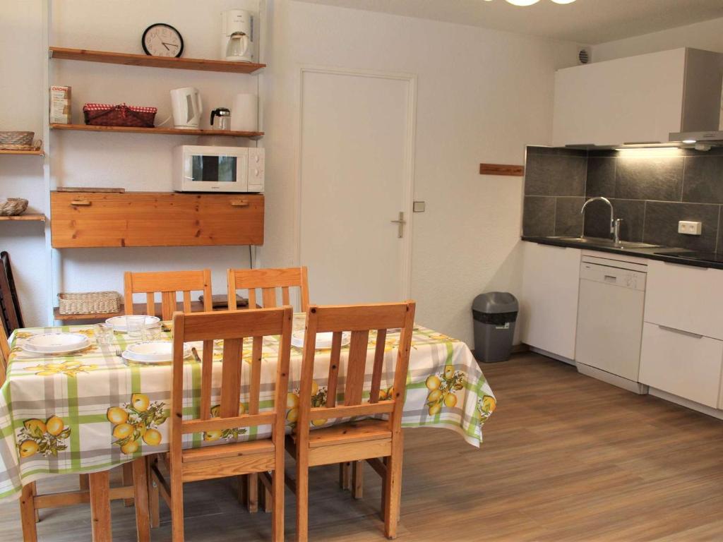 eine Küche und ein Esszimmer mit einem Tisch und Stühlen in der Unterkunft Appartement Vars, 3 pièces, 8 personnes - FR-1-330B-125 in Vars