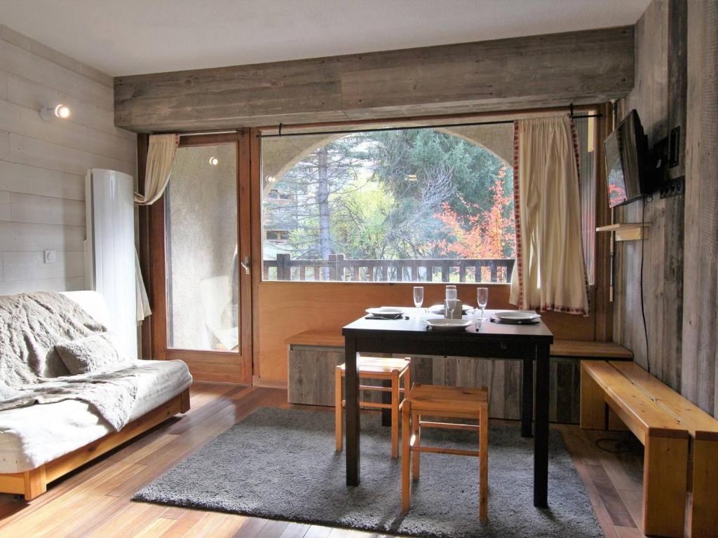 um quarto com uma mesa, uma cama e uma janela em Appartement Saint-Chaffrey , 2 pièces, 6 personnes - FR-1-330E-109 em Saint-Chaffrey