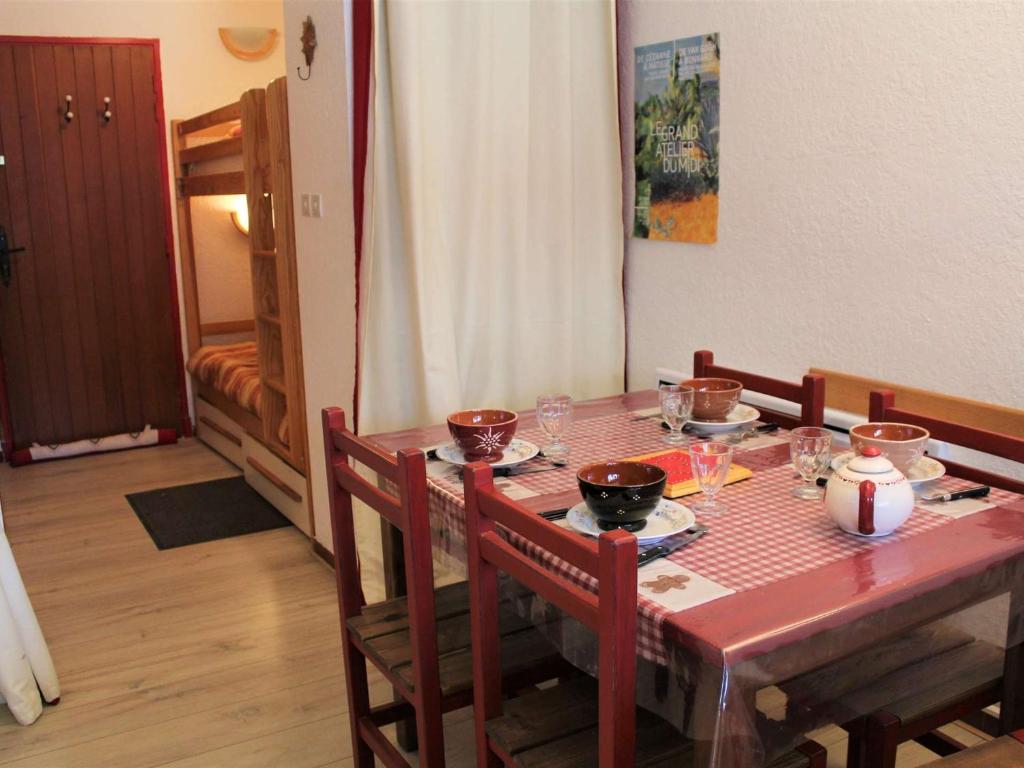 - une table à manger avec des bols et des assiettes dans l'établissement Studio cabine & coin montagne avec balcon, 4 couchages, à 100m des pistes - Vars - FR-1-330B-122, à Vars
