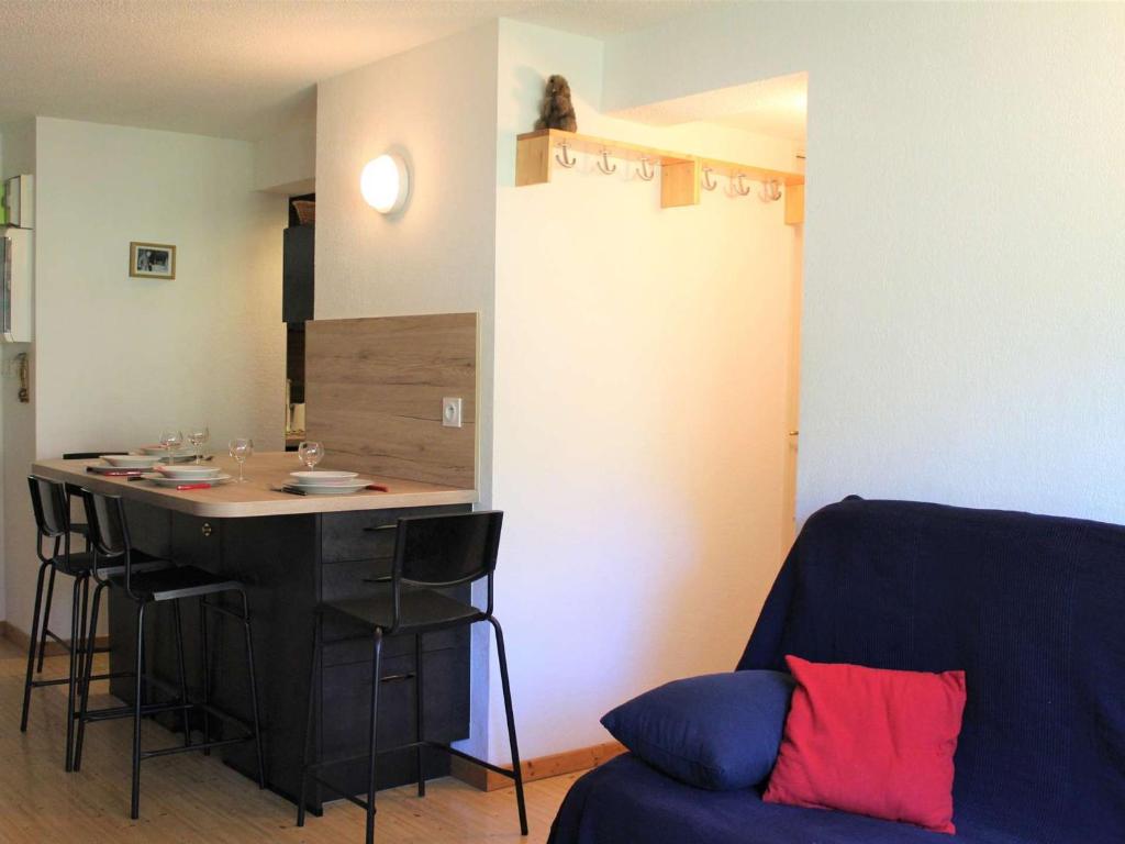 ein Wohnzimmer mit einem blauen Sofa und einer Küche in der Unterkunft Appartement Vars, 2 pièces, 4 personnes - FR-1-330B-129 in Vars