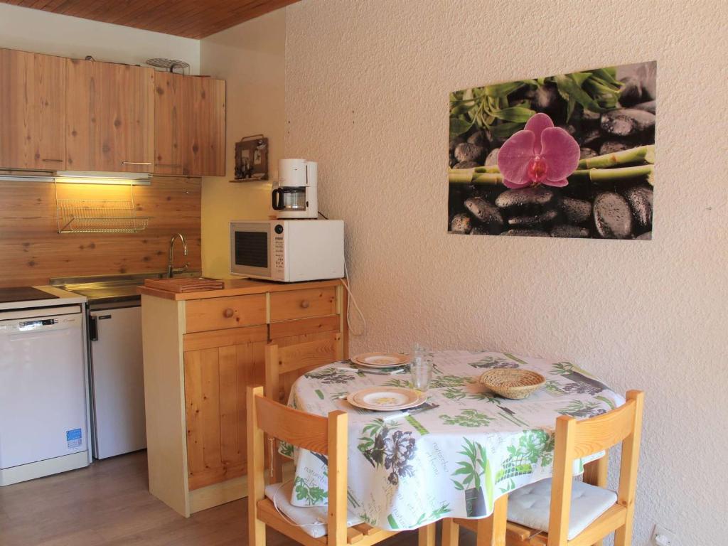 una piccola cucina con tavolo e tovaglia di Appartement Vars, 1 pièce, 2 personnes - FR-1-330B-131 a Vars