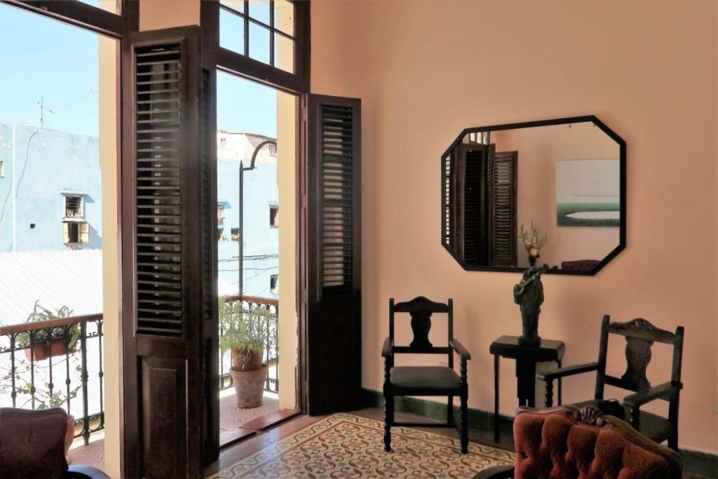 sala de estar con espejo y silla en Casa Sahari Appartement 2, en La Habana