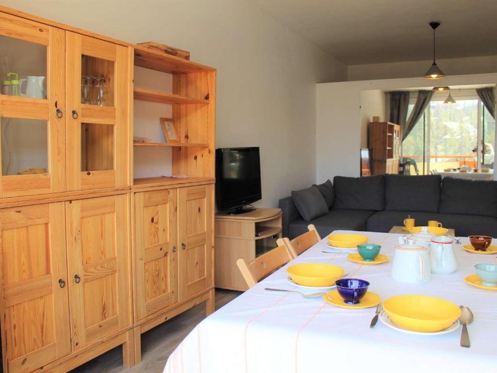 una sala de estar con una mesa con platos amarillos. en Appartement Vars, 2 pièces, 6 personnes - FR-1-330B-98, en Vars