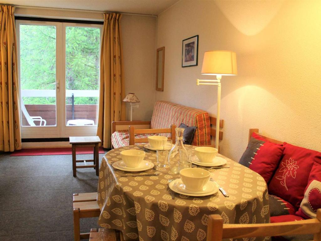 una sala de estar con una mesa con platos. en Appartement Vars, 1 pièce, 4 personnes - FR-1-330B-104 en Vars