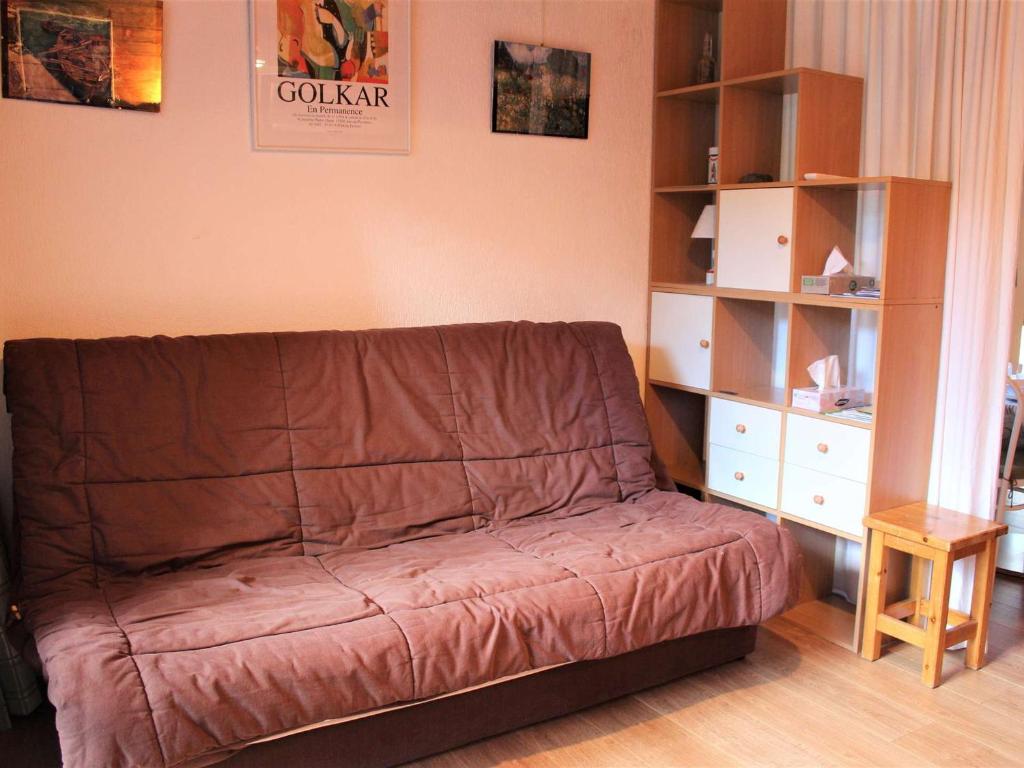 een bruine bank in een woonkamer met een boekenplank bij Appartement Vars, 1 pièce, 4 personnes - FR-1-330B-115 in Vars