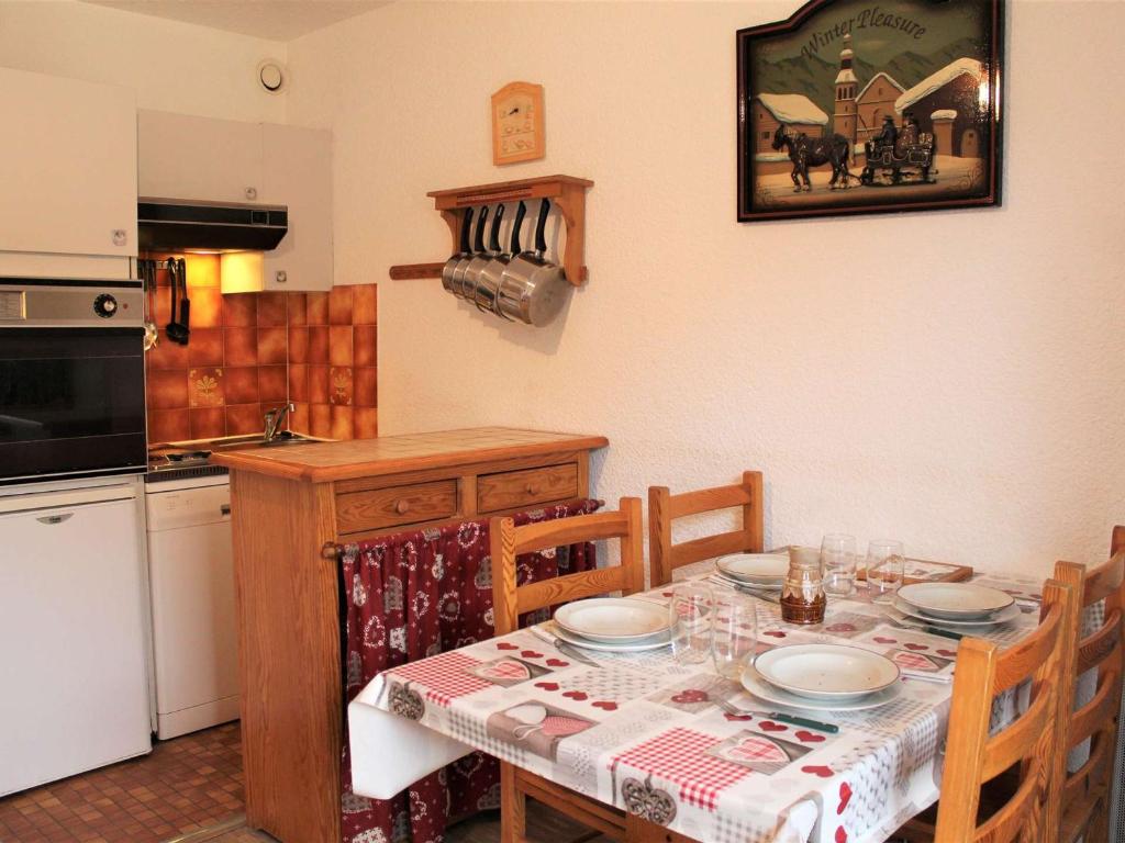 a kitchen with a table with chairs and a tableablish at Appartement Vars, 1 pièce, 4 personnes - FR-1-330B-140 in Vars