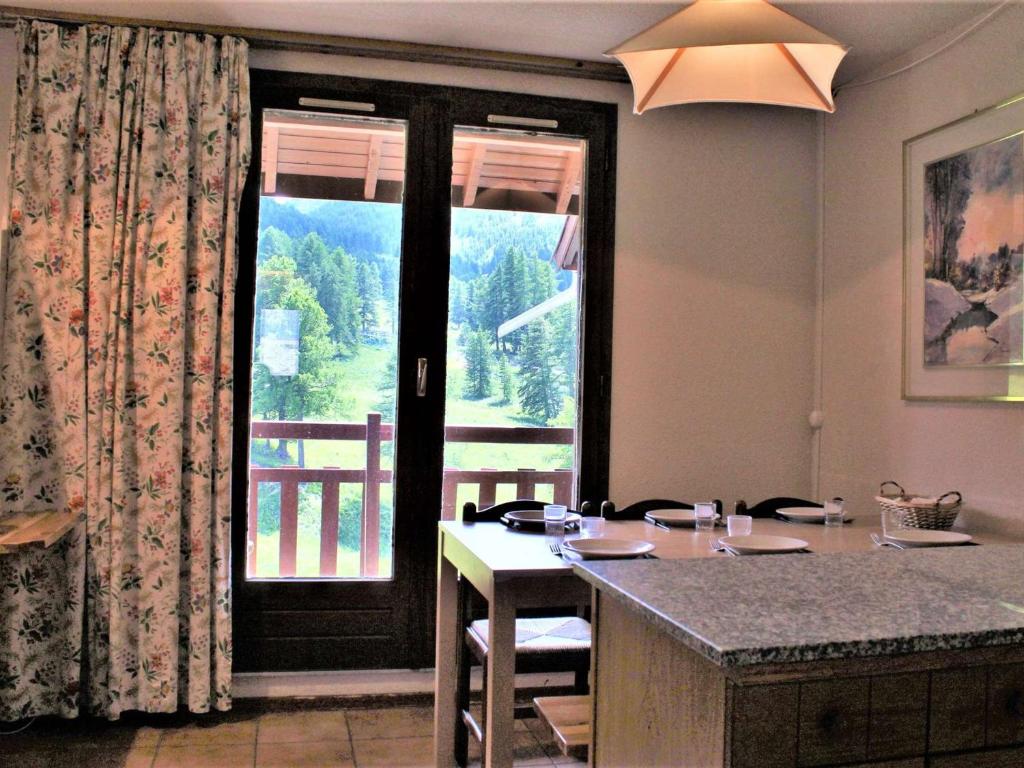 a kitchen with a table and a large window at Appartement Risoul, 3 pièces, 6 personnes - FR-1-330-502 in Risoul