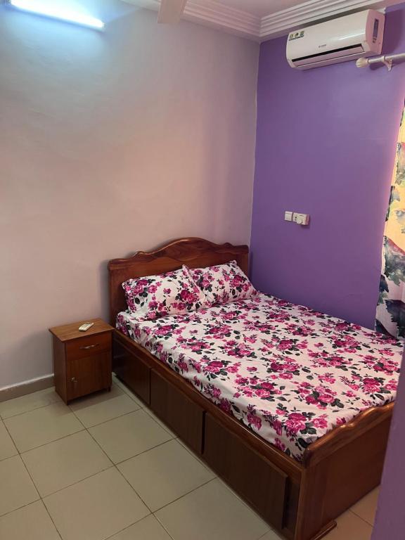 a bedroom with a bed with a floral comforter at Ouedraogo Property Management in Ouagadougou