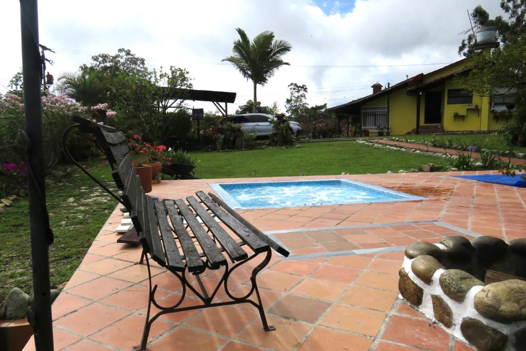 a bench sitting next to a swimming pool at Casa Campo Los Lucero, con Hidrospa in Piedecuesta