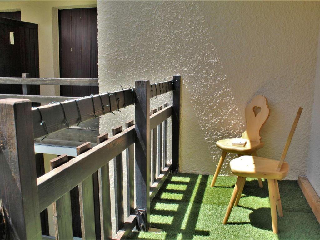 a chair and a guitar sitting on a balcony at Appartement Risoul, 1 pièce, 4 personnes - FR-1-330-496 in Risoul