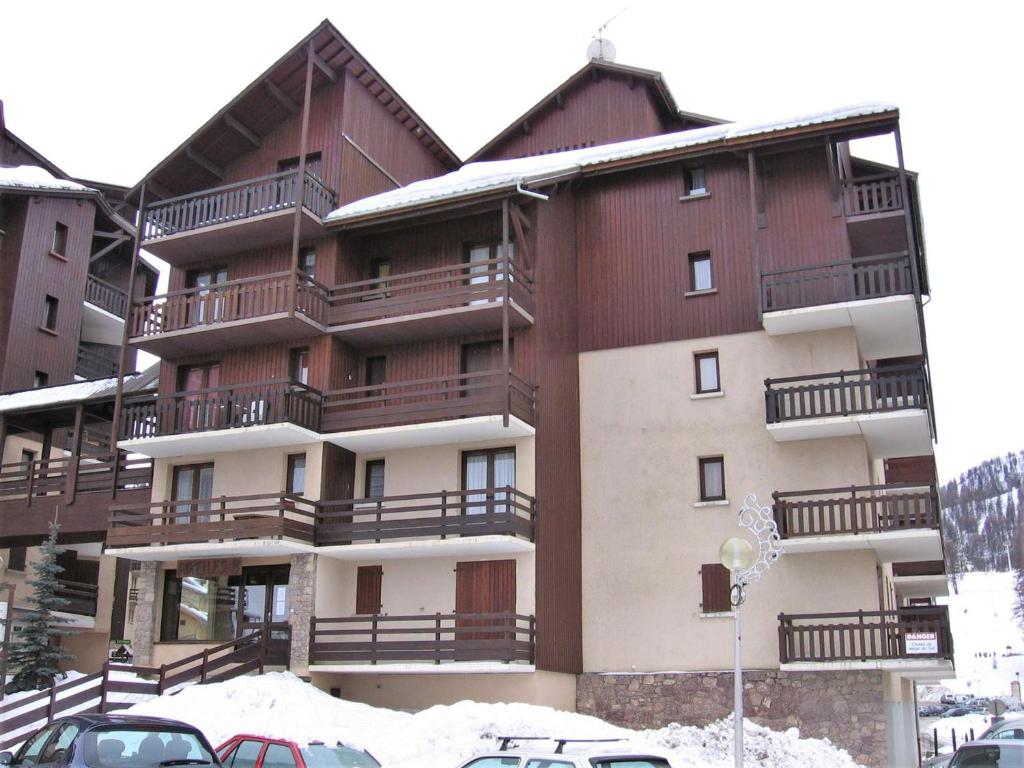 a building with balconies and cars parked in the snow at Appartement Risoul, 1 pièce, 4 personnes - FR-1-330-496 in Risoul
