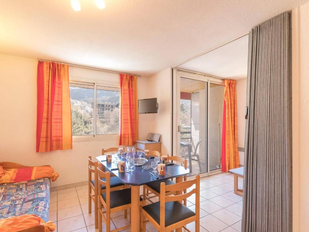 uma sala de jantar com uma mesa e cadeiras num quarto em Appartement Briançon, 2 pièces, 4 personnes - FR-1-330C-5 em Briançon