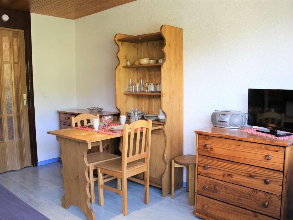 Il comprend une cuisine avec une table et des chaises en bois ainsi qu'un bureau. dans l'établissement Appartement Vars, 1 pièce, 4 personnes - FR-1-330B-85, à Vars