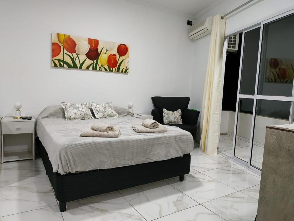 伊瓜蘇港的住宿－Tres Fronteras Apart 1，一间卧室配有带毛巾的床