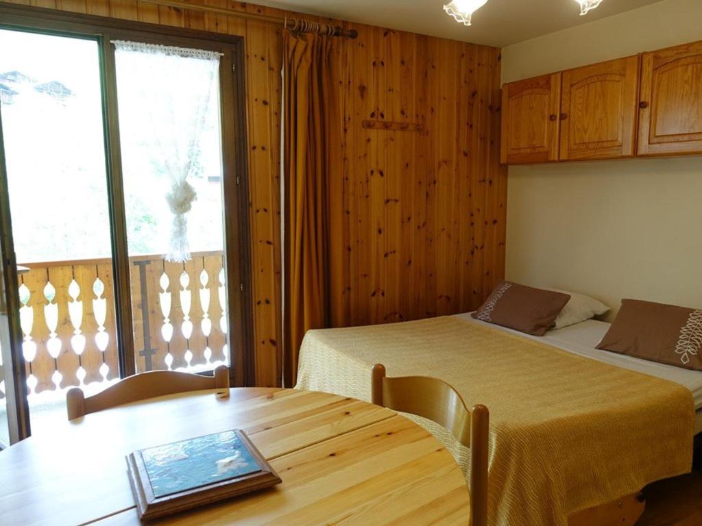 Una habitación con dos camas y una mesa y una ventana. en Appartement cosy 4 pers, skis aux pieds, balcon, parking, 2 étoiles - Location dim. à dim. en hiver - FR-1-342-191, en Arêches